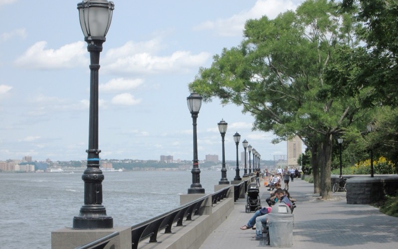 Lampposts, railing and trees along the Battery Park City Esplanade beside the Hudson River