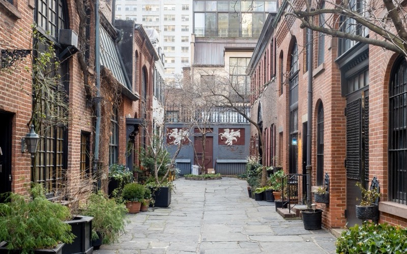 Brick carriage houses with planters facing the flagstone lane of Sniffen Court, Murray Hill, Manhattan