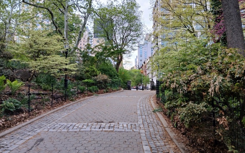 Cobblestone path between planted borders and trees in Carl Schurz Park, Upper East Side, Manhattan