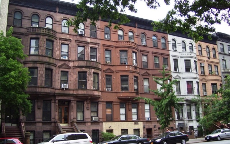 Row of brownstone and brick townhouses with bay windows on West 96th Street, Upper West Side, Manhattan